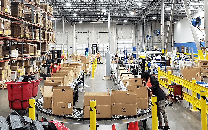 Four strategies to reduce warehouse labor costs. Working in a warehouse.