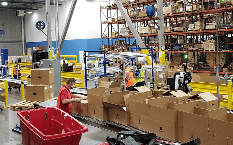 Workers in a warehouse. Four strategies to reduce warehouse labor costs.